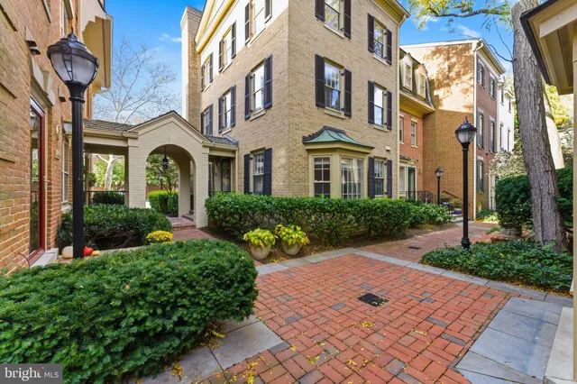 a front view of a multi story residential apartment building with yard and entryway