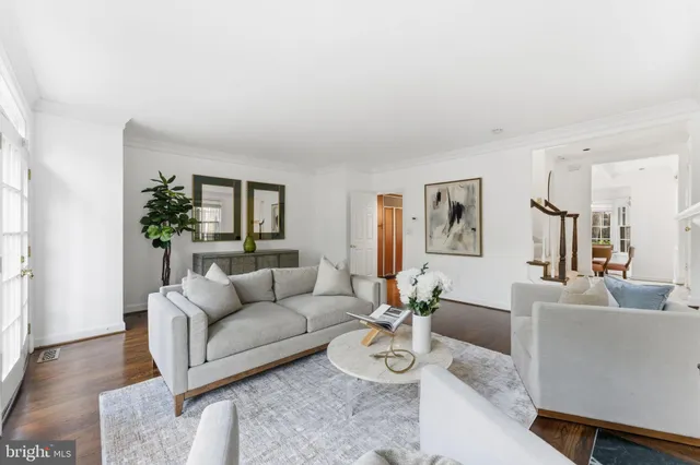 a living room with furniture and three large window