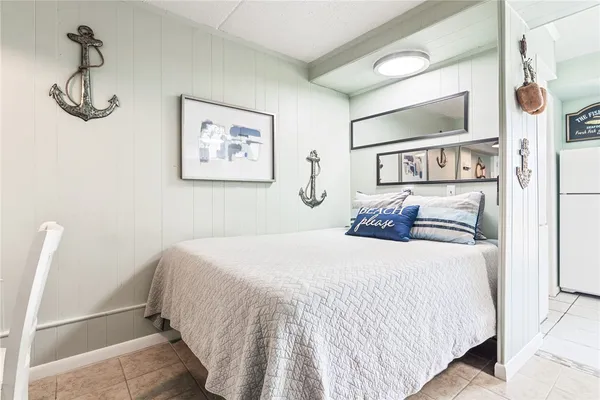 a bedroom with a large bed and paintings on the wall