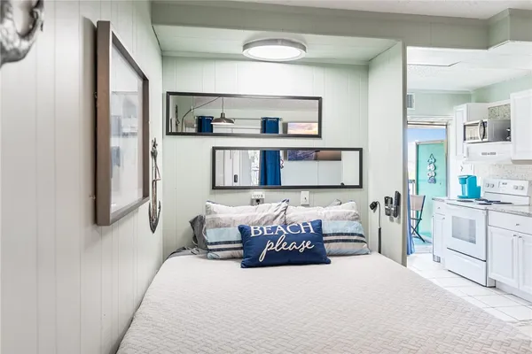 a bedroom with a large bed and a view of kitchen
