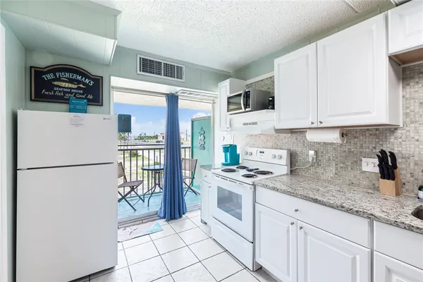 a kitchen with stainless steel appliances granite countertop a refrigerator sink and stove