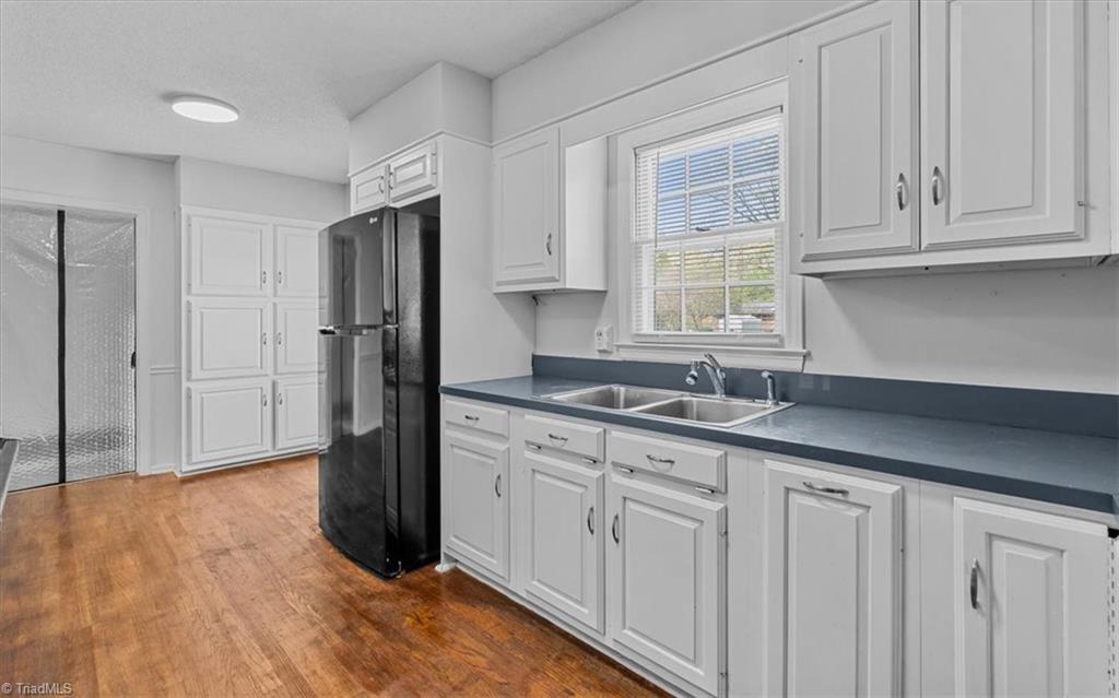 5334 Sherrie Drive High Point, NC 27263 - Photo 13 of 36 Bright, functional kitchen featuring crisp white cabinetry, durable countertops, and stainless-style sink positioned beneath a natural light-filled window.