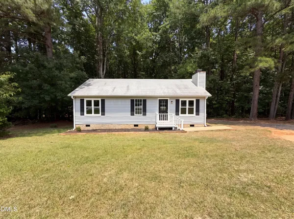 a front view of a house with a yard table and chairs