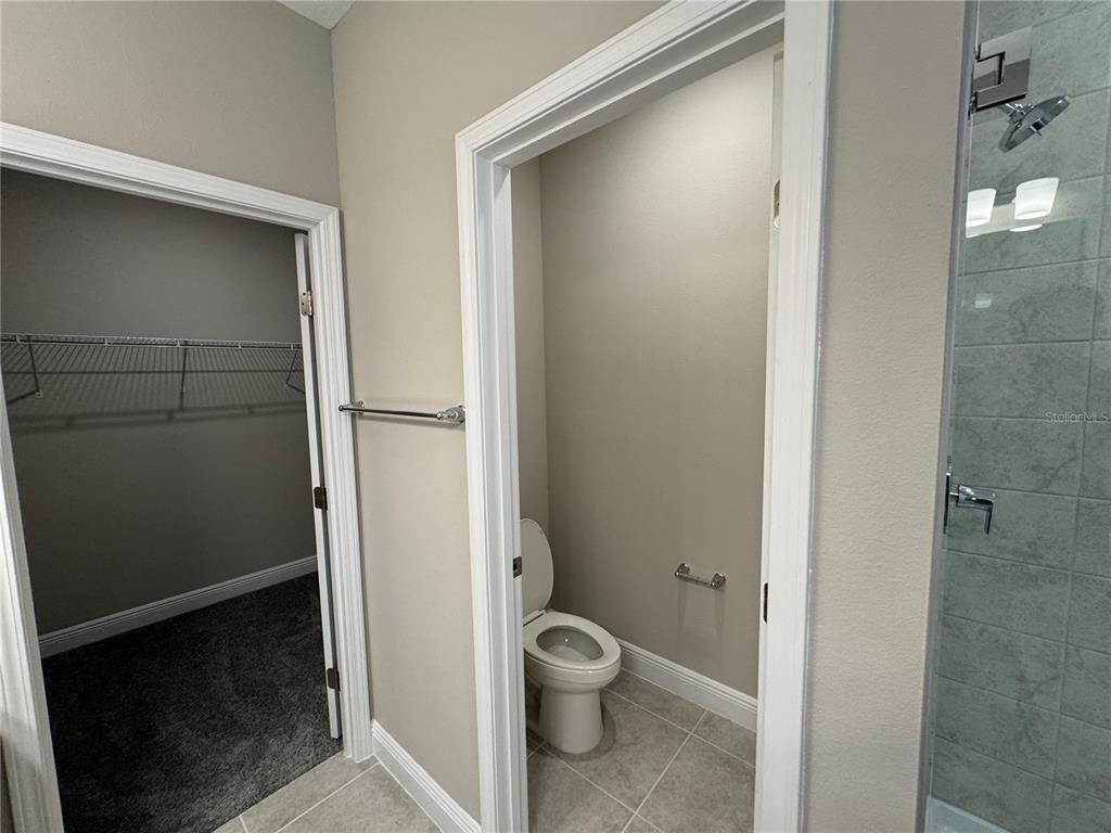 16434 Hamlin Hills Road Winter Garden, FL 34787 - Photo 27 of 50 a bathroom with a granite countertop toilet and a shower