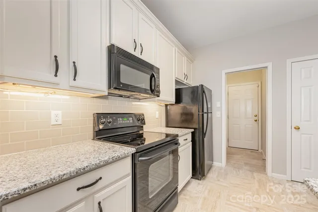 a kitchen with stainless steel appliances granite countertop a stove microwave and refrigerator