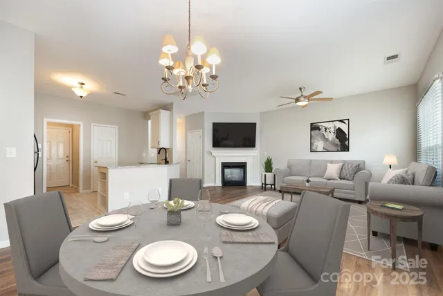a view of a dining room with furniture a chandelier and wooden floor