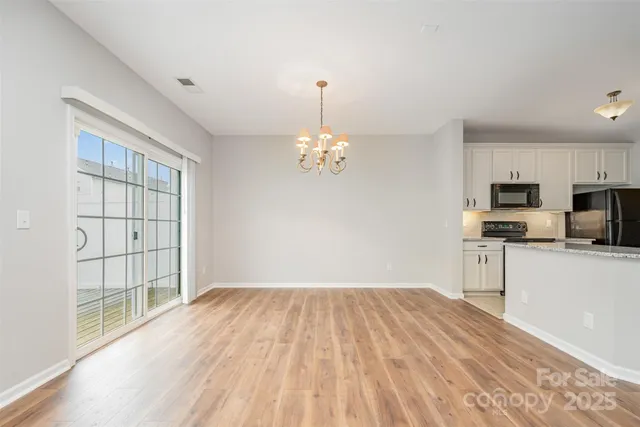 a view of empty room with wooden floor and window
