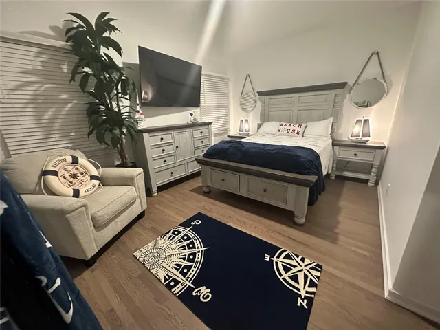a bedroom with furniture and a flat screen tv