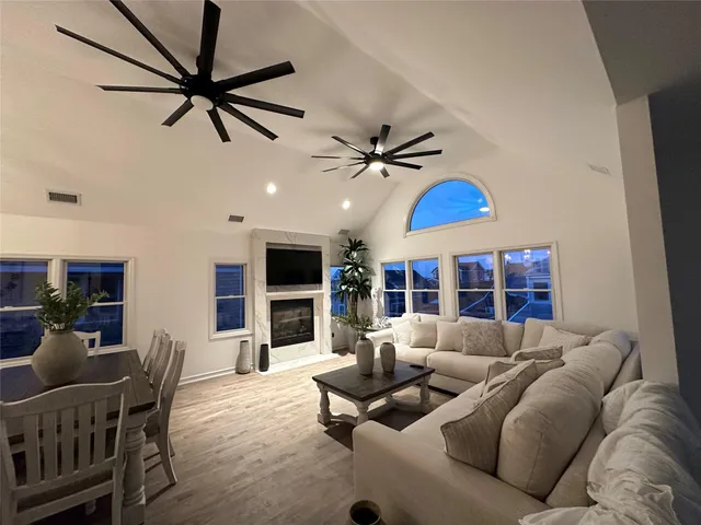 a living room with furniture a ceiling fan and a rug