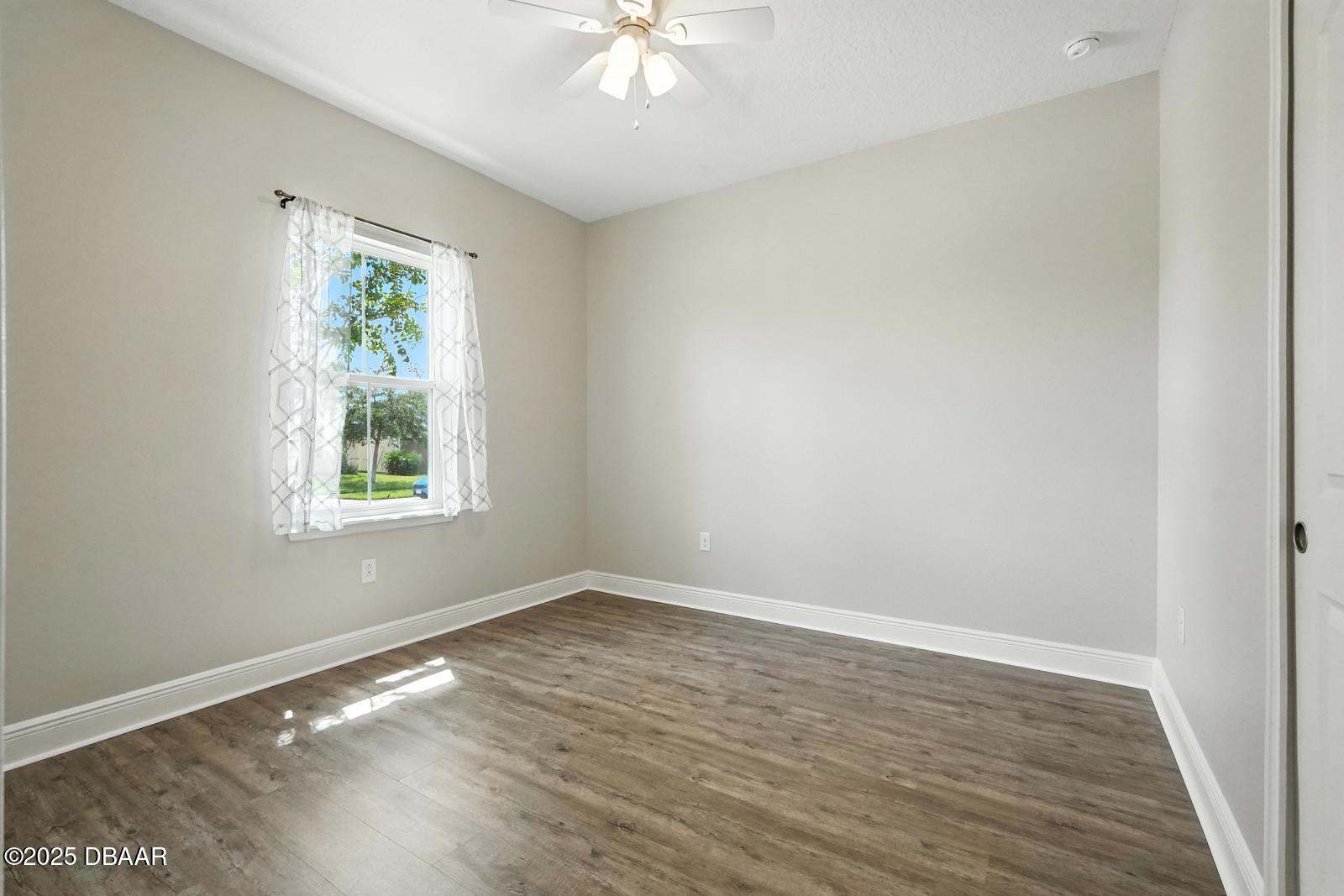 5428 Estero Loop Port Orange, FL 32128 - Photo 8 of 41 wooden floor in an empty room with a window