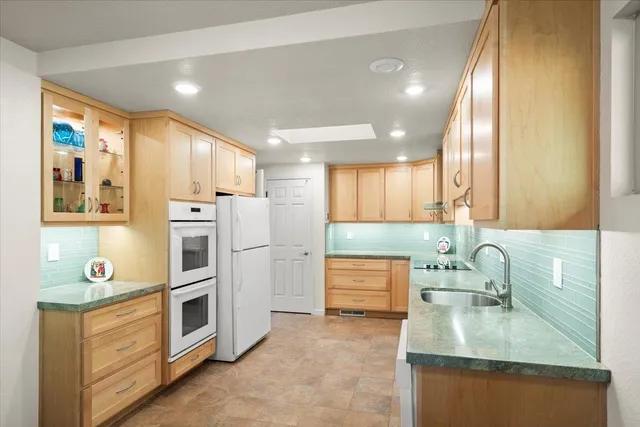 a kitchen with kitchen island granite countertop a sink a cabinets and window stainless steel appliances