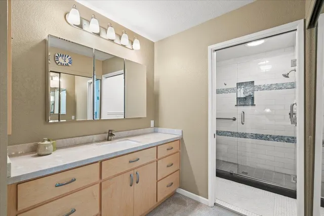 a spacious bathroom with a shower sink and mirror
