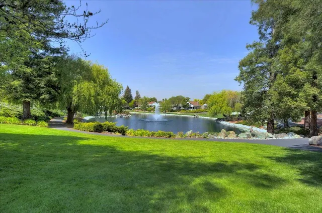 a swimming pool with outdoor seating and lake