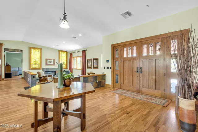 a kitchen with stainless steel appliances granite countertop a refrigerator a stove a kitchen island with chairs and wooden floor