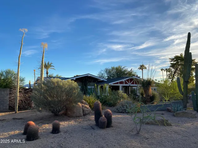 a view of a house with a yard and potted plants