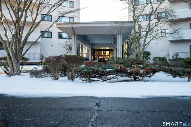 a living room with furniture a flat screen tv and kitchen view