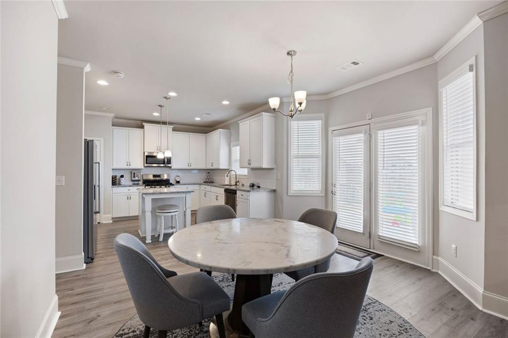 641 Little Bear Loop Canton, GA 30114 - Photo 11 of 37 a kitchen with kitchen island a dining table chairs and white cabinets