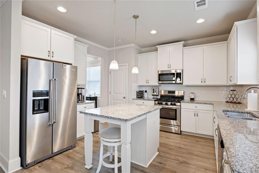 641 Little Bear Loop Canton, GA 30114 - Photo 12 of 37 a kitchen with stainless steel appliances granite countertop a refrigerator a stove microwave and sink