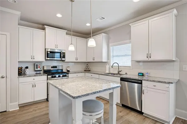 a kitchen with granite countertop white cabinets white appliances and sink