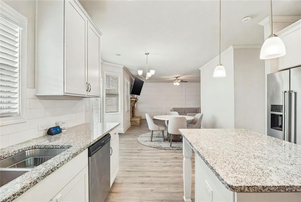 641 Little Bear Loop Canton, GA 30114 - Photo 14 of 37 a kitchen with stainless steel appliances granite countertop a sink dishwasher and a stove with wooden floor