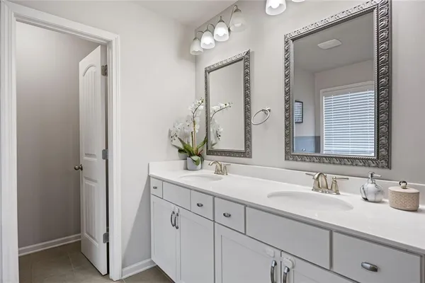 a bathroom with double vanity sinks and a mirror
