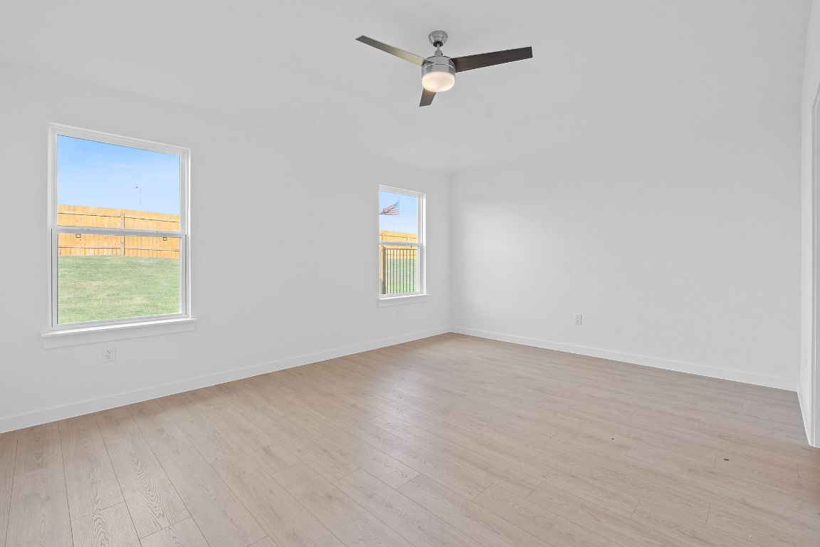 9701 Oxbow Strap Drive Austin, TX 78724 - Photo 20 of 34 Empty room with light wood finished floors and ceiling fan