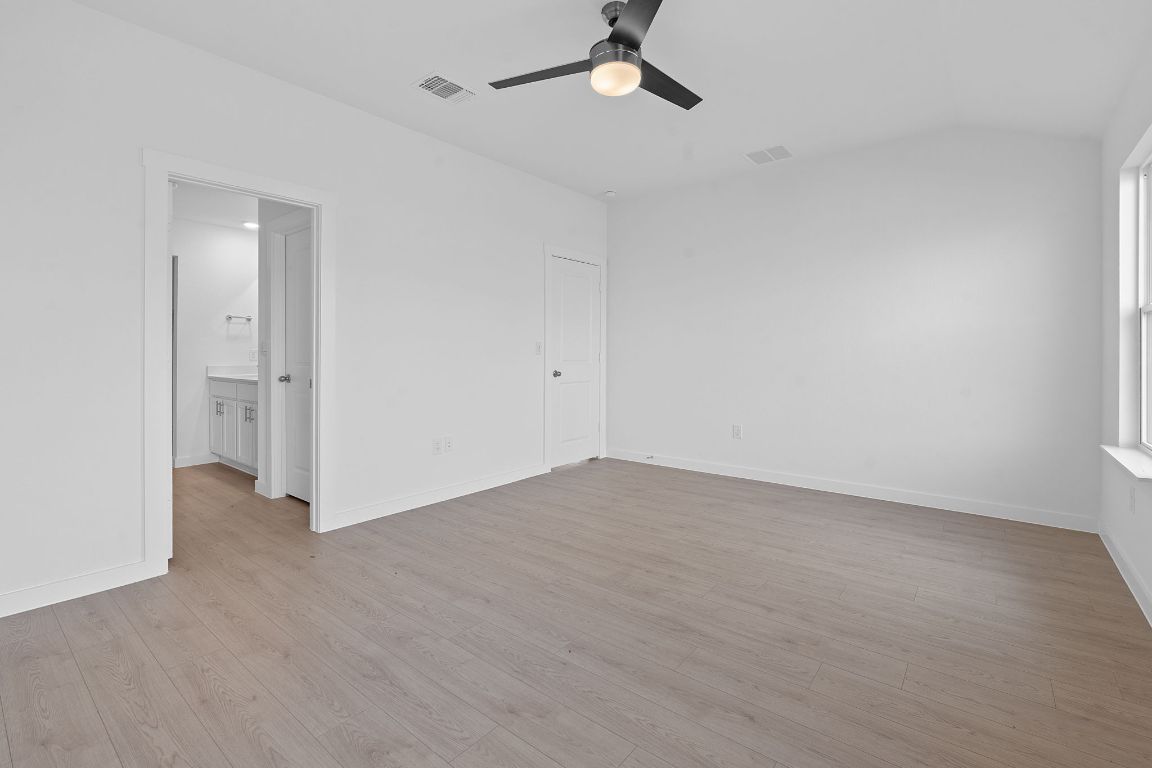 9701 Oxbow Strap Drive Austin, TX 78724 - Photo 22 of 34 Unfurnished bedroom with light wood finished floors, ceiling fan, and lofted ceiling