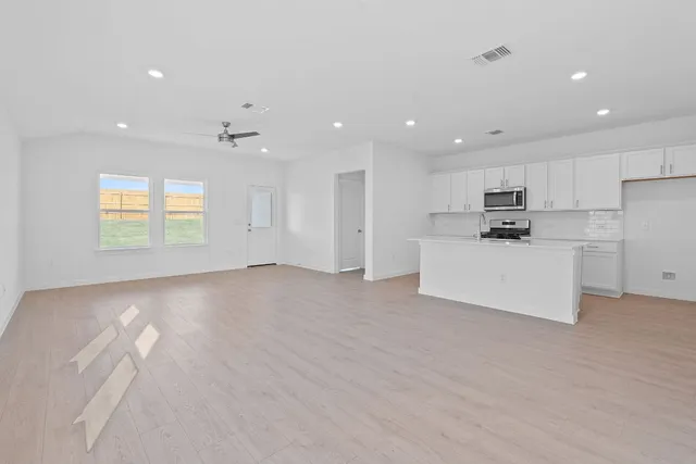 a view of a kitchen with a sink and dishwasher a refrigerator with wooden floor