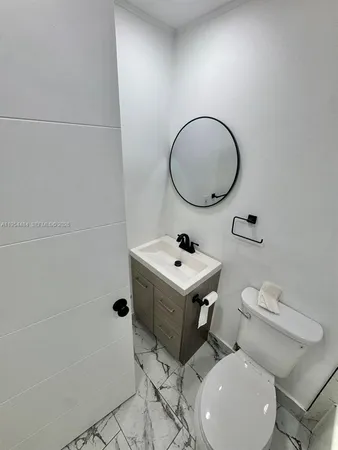 a bathroom with a toilet a sink and a mirror