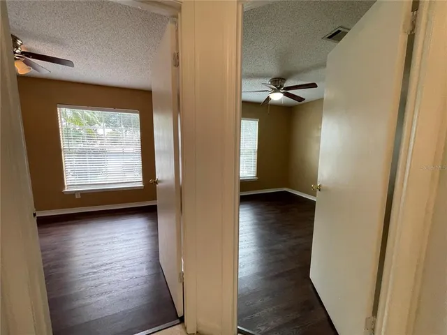 a view of a hallway with wooden floor and closet