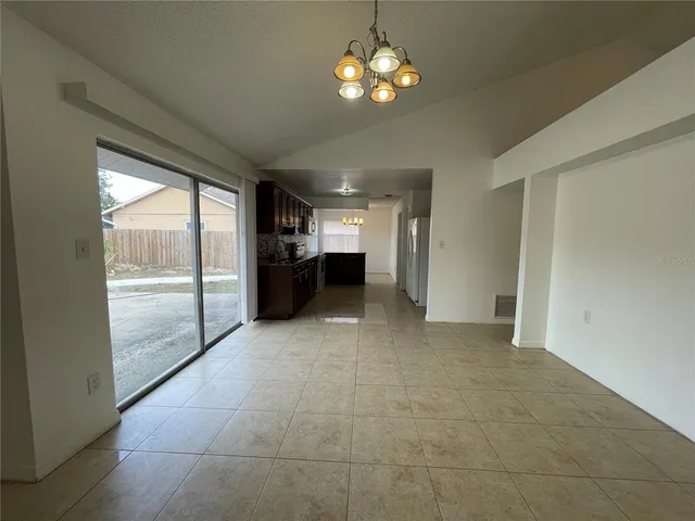 a view of a livingroom with a chandelier fan and windows