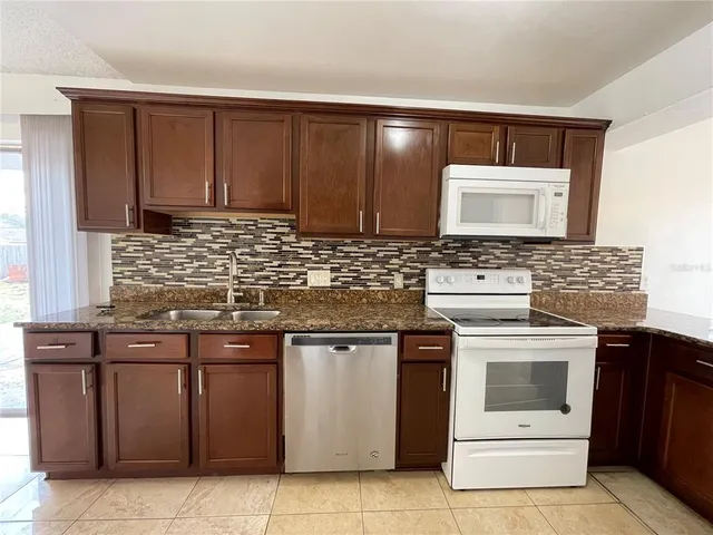 a kitchen with stainless steel appliances granite countertop a stove sink and cabinets