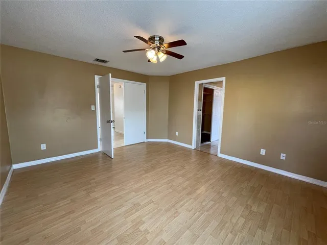 a view of an empty room with a ceiling fan and a window
