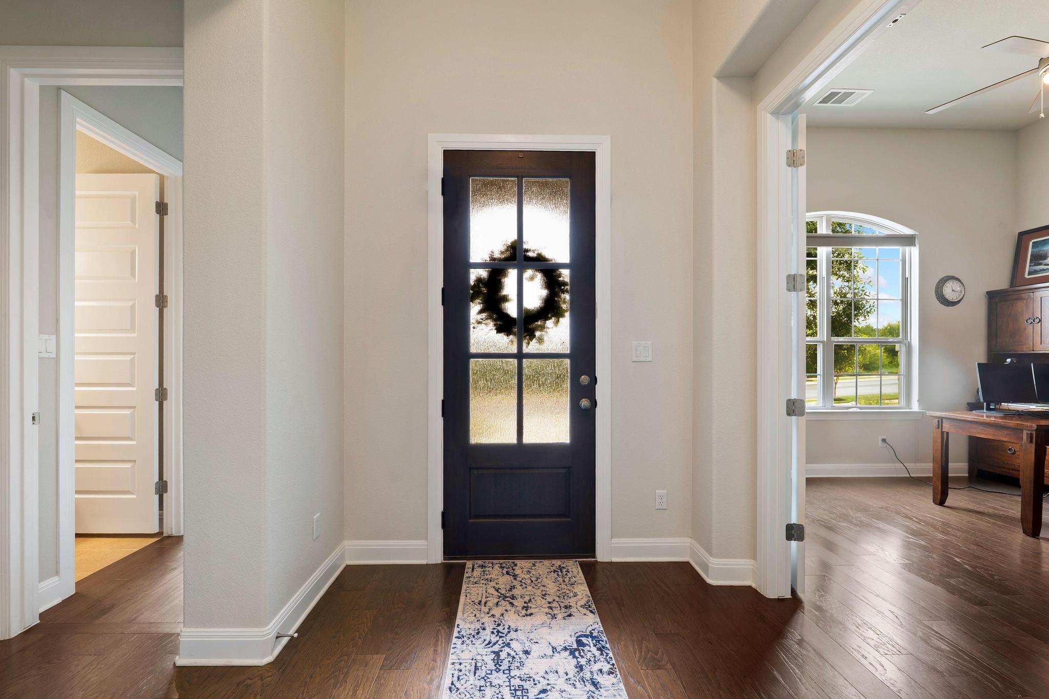 1009 Legacy Crossing Georgetown, TX 78628 - Photo 4 of 40 Enter into a welcoming foyer with rich hardwood flooring and a stylish front door.