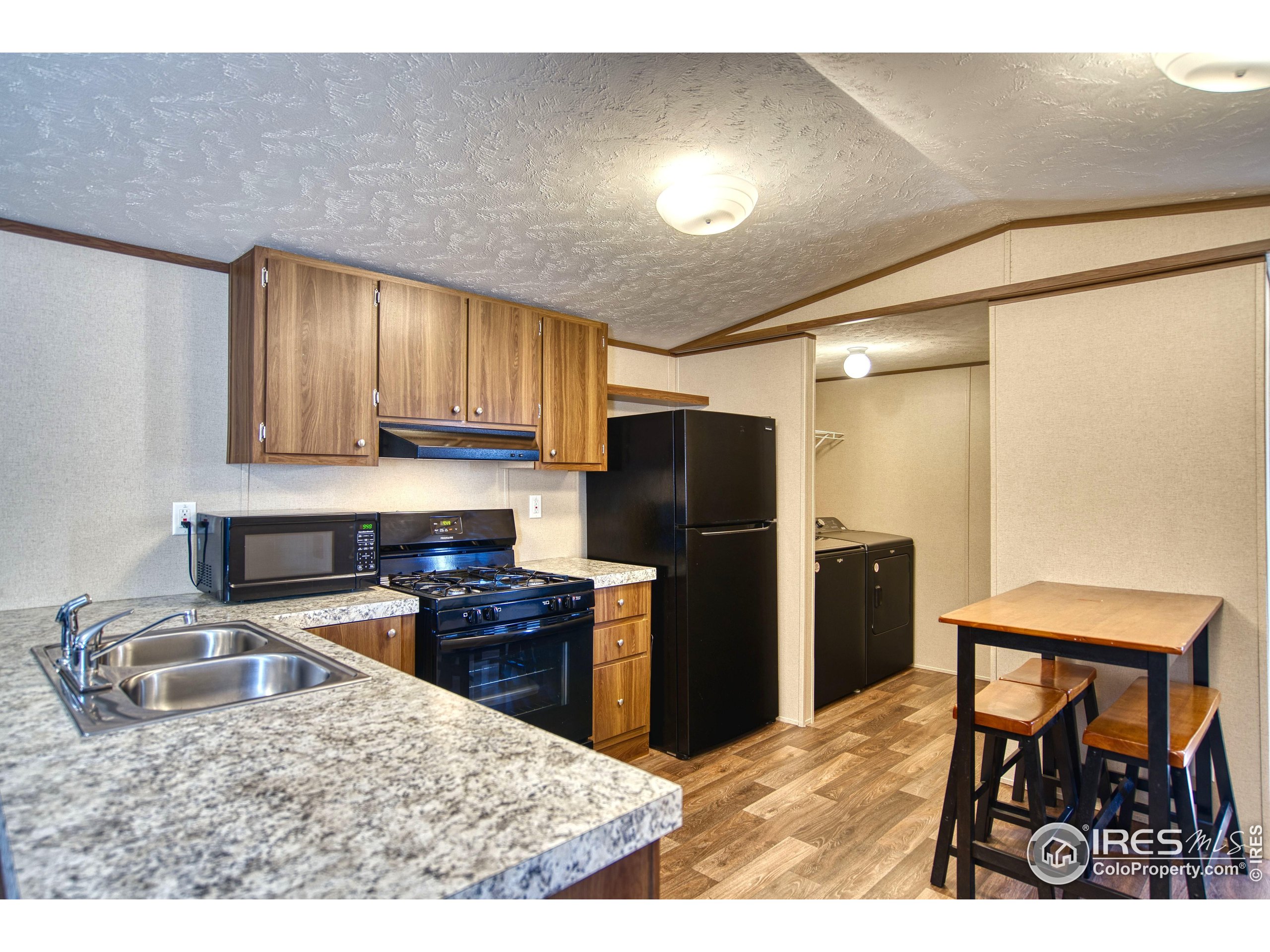 a kitchen with stainless steel appliances kitchen island granite countertop a refrigerator and a stove top oven