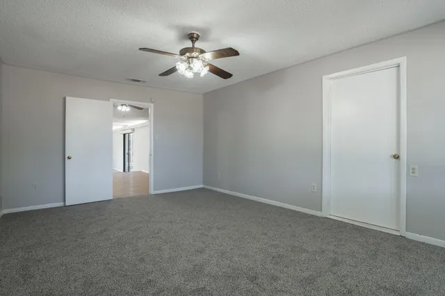 a view of a hallway with wooden floor and cabinets