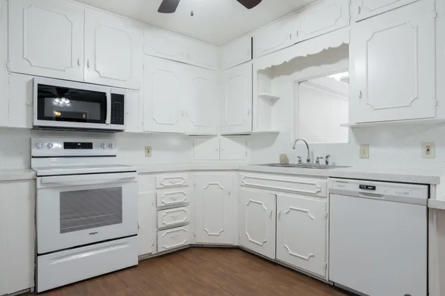 a kitchen with white cabinets stainless steel appliances and sink