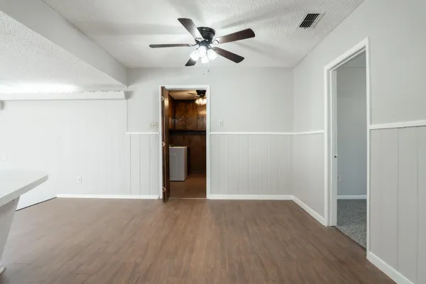 a view of an empty room with wooden floor