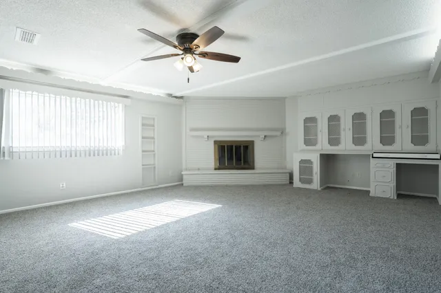a view of a livingroom with a fireplace and a window