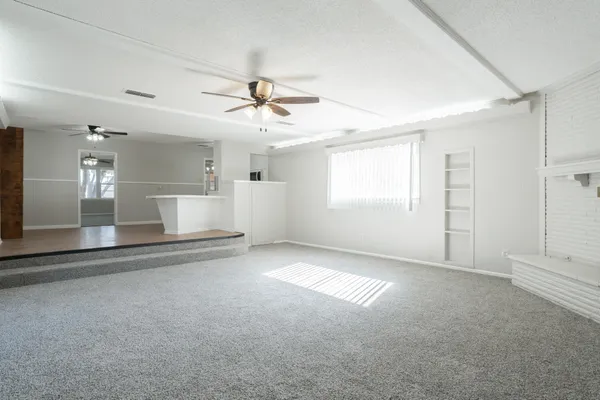 a view of a livingroom with a ceiling fan and window