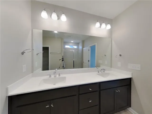 a bathroom with double vanity sinks and a mirror