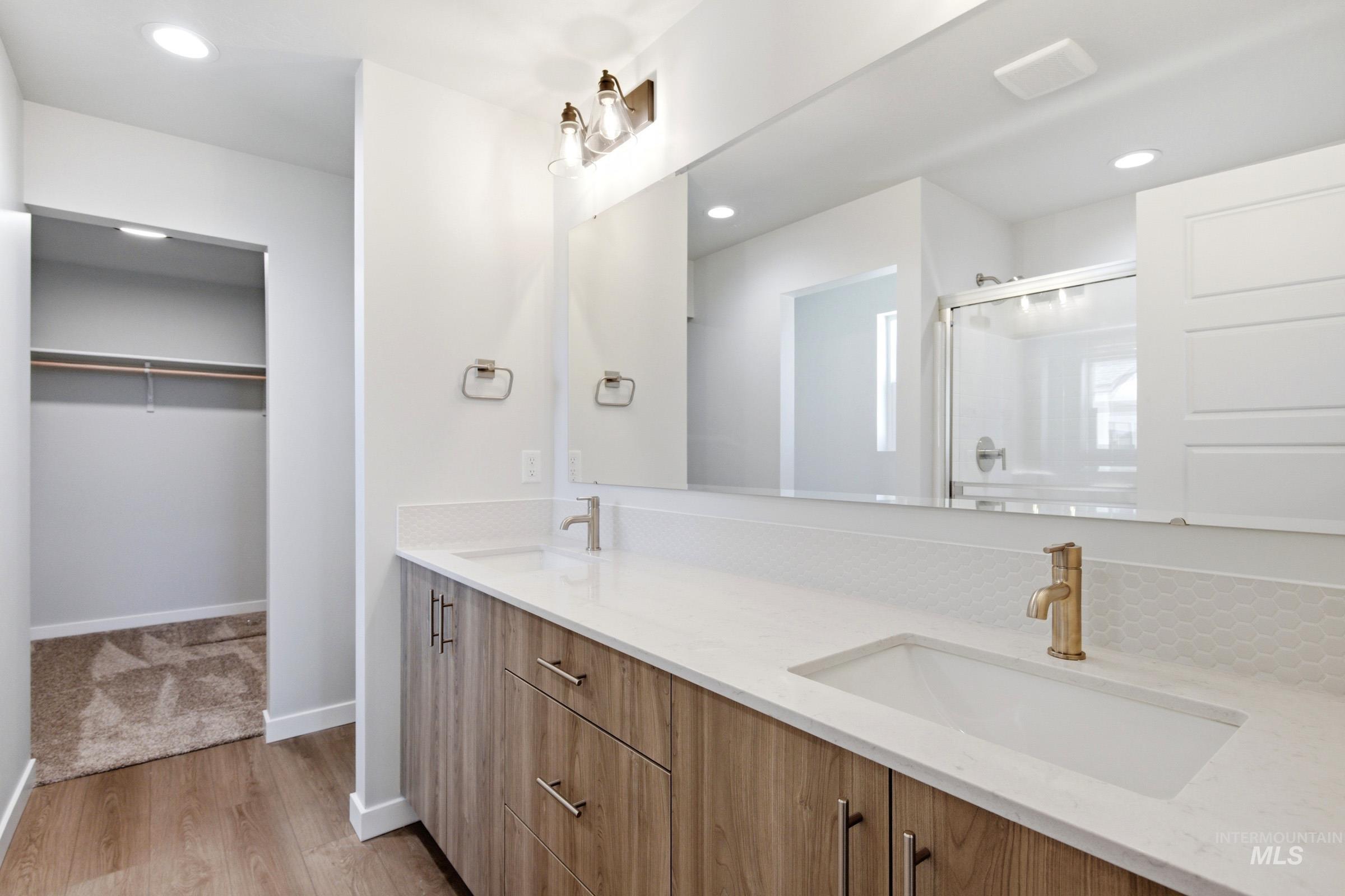 1184 West Jasper Street Meridian, ID 83642 - Photo 16 of 18 Bathroom featuring a dual vanity with wood-finish cabinetry, white countertops, and undermount sinks