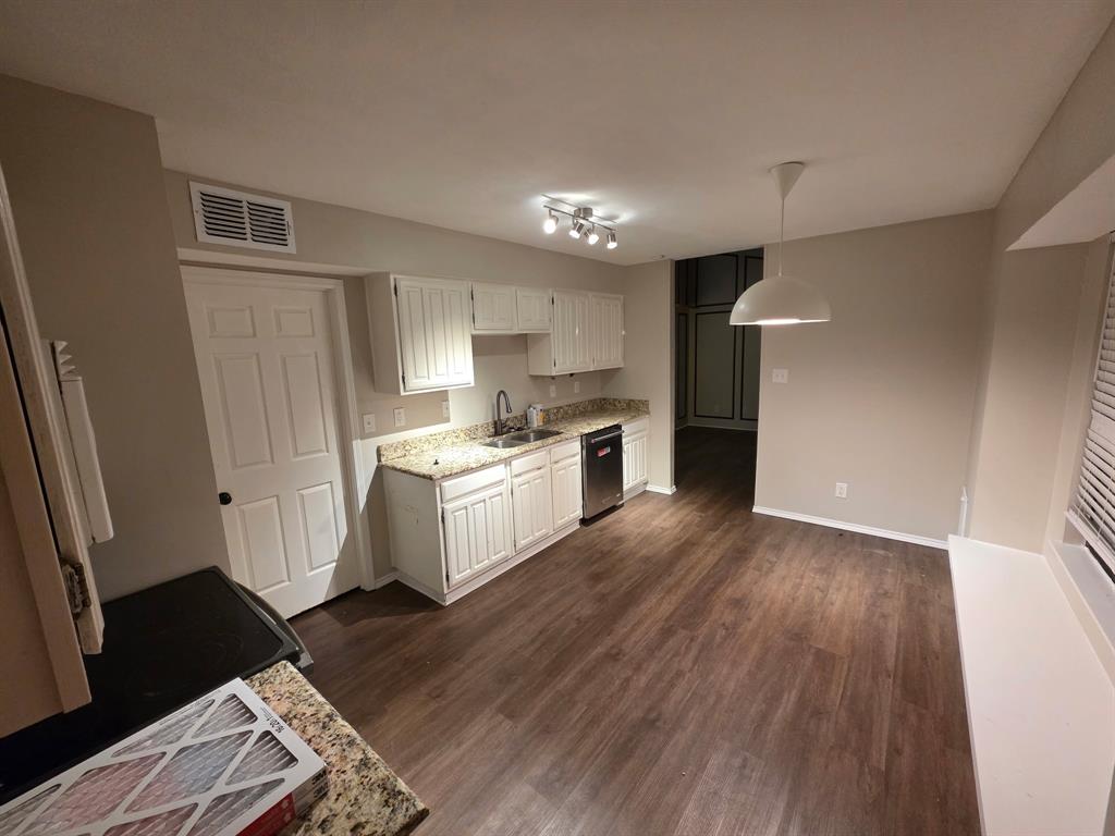 Undisclosed Address Dallas, TX 75238 - Photo 4 of 13 a kitchen with granite countertop a refrigerator oven a sink dishwasher and white cabinets with wooden floor