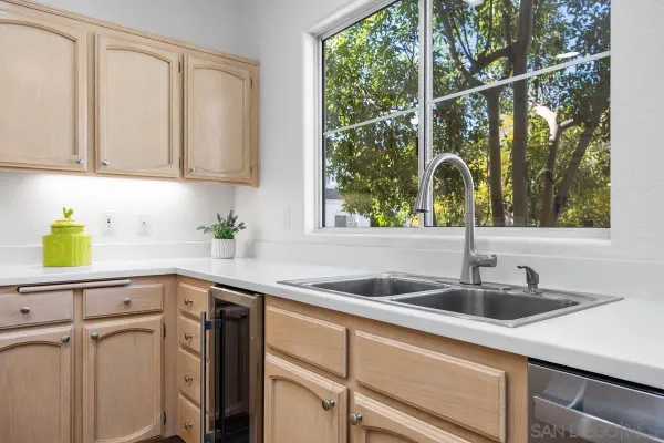 a kitchen with stainless steel appliances a sink a counter cabinets and a window