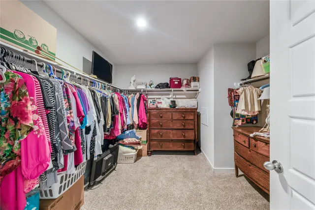 a view of walk in closet with clothes and shoes