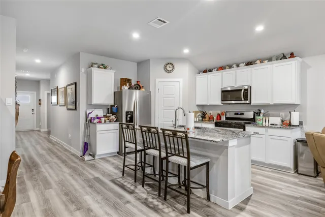 a kitchen with white cabinets and stainless steel appliances