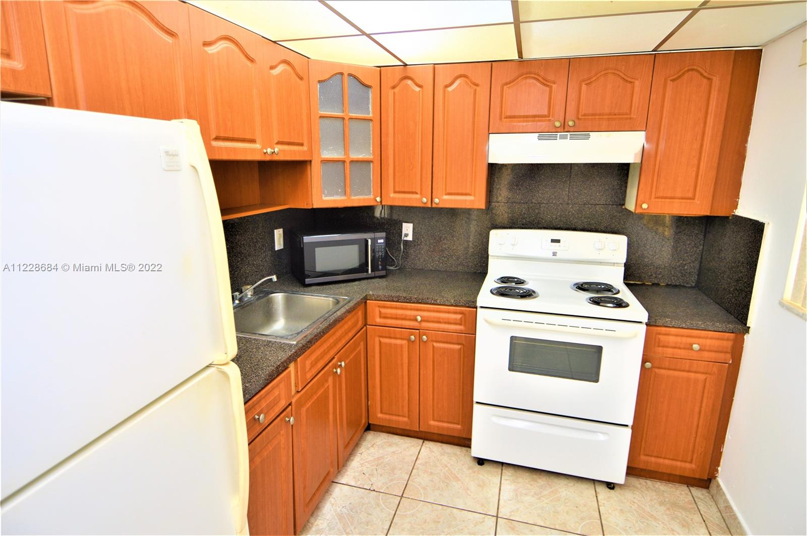 a kitchen with a stove top oven and cabinets
