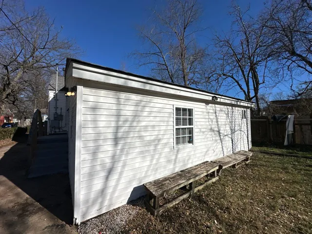 a backyard of a house with wooden fence and large windows