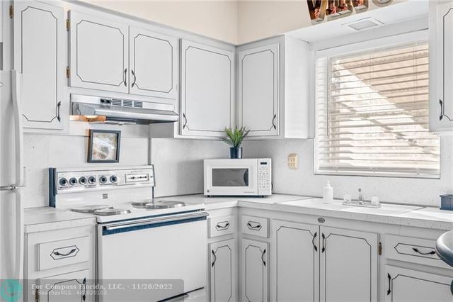 a kitchen that has a lot of cabinets in it and appliances