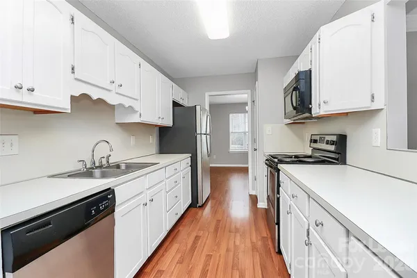 a kitchen with cabinets appliances a sink and a counter space
